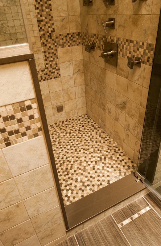 Abbey's bathroom with step-in shower, artistic tile design, quartz trim, and glass walls