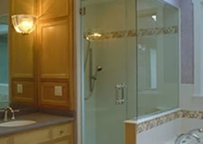 Abbey's custom bathroom design with light wood cabinets, step-in shower, and bath tub