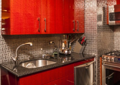 Abbey's modern custom design kitchen with highly polished red cabinets, stainless accents