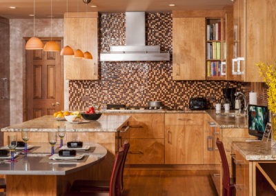 Abbey's modern custom design kitchen with highly polished red birch cabinets and unique stainless hood