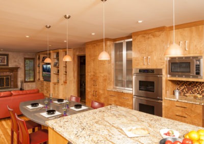 Abbey's modern design kitchen and wall unit are of highly polished red birch cabinets