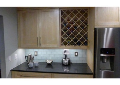 Abbey's custom kitchen with modern light wood cabinets, built in wine rack