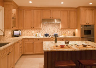Abbey's warm custom kitchen design with light wood cabinets, stainless appliances, and prep island