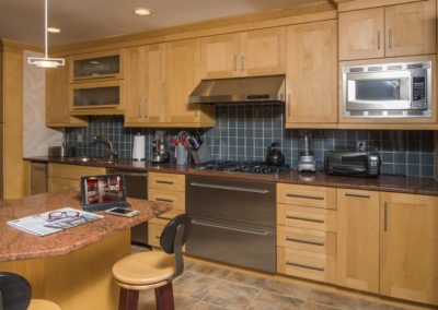 Abbey's custom kitchen design with light wood cabinets and stainless appliances