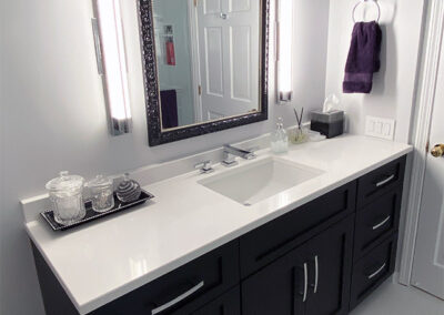 Abbey's clean galley bathroom design in white, rich wood cabinet
