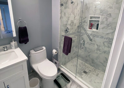 Abbey's bathroom renovation, quick elegant, carrara marble tile, new sink cabinet, toilet & floor